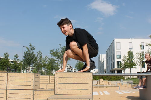 Jugendlicher springt dynamisch über ein Hindernis