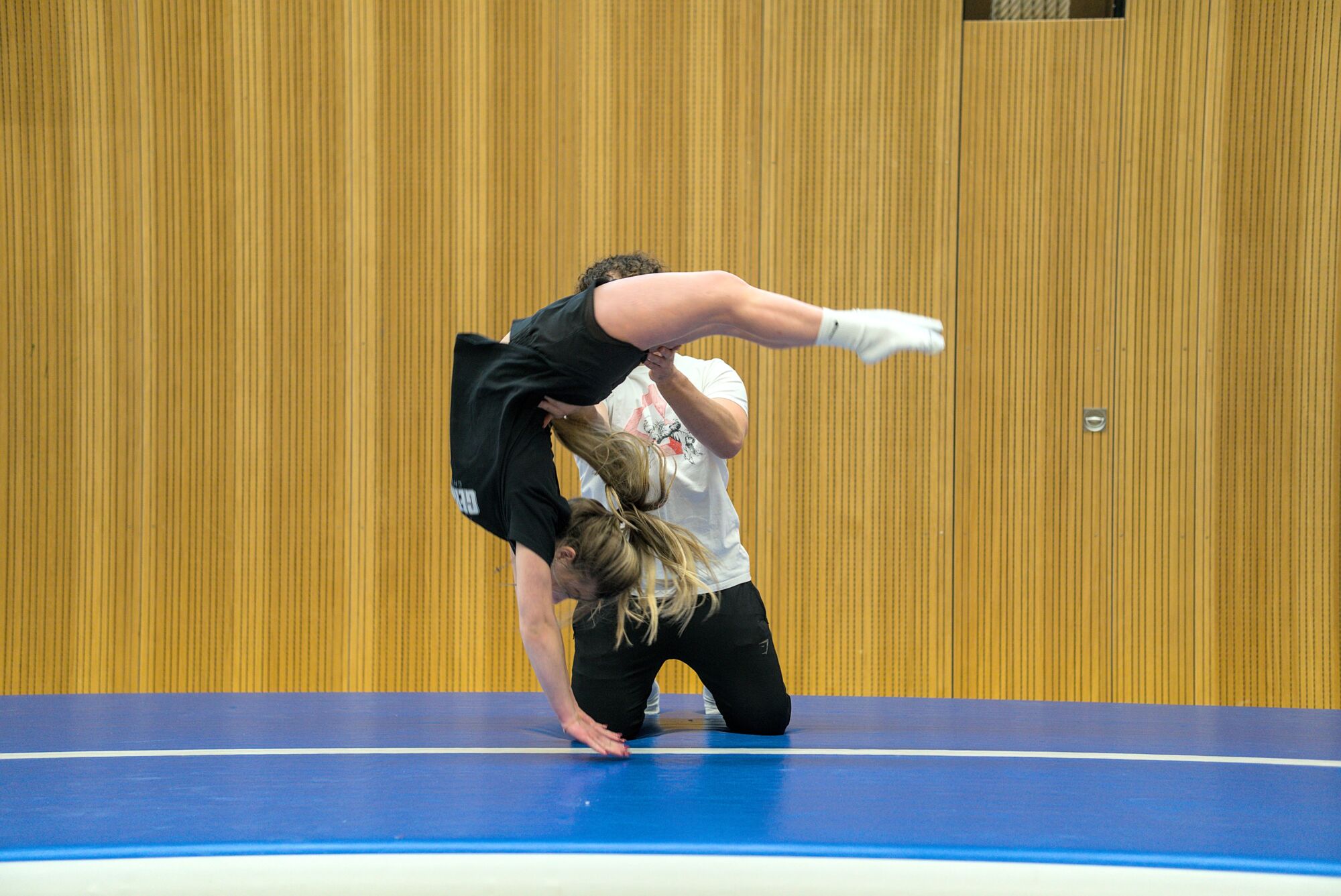 Trainer gibt Hilfestellung beim Flickflack