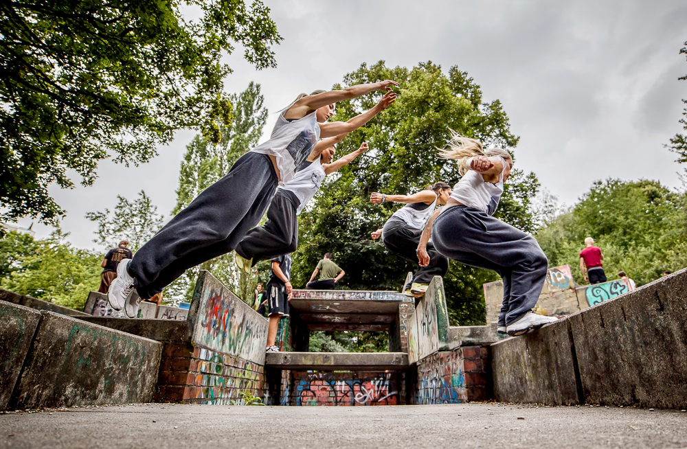 Frau springt über eine Lücke beim Parkour-Training